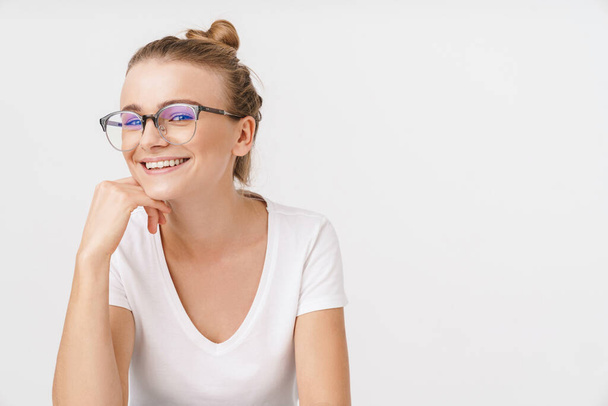 Photo of beautiful happy woman in eyeglasses smiling and looking at camera isolated over white background - Zdjęcie, obraz