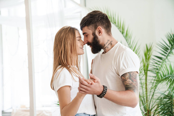 Image of romantic smiling couple hugging and dancing in bright room at home - Fotoğraf, Görsel