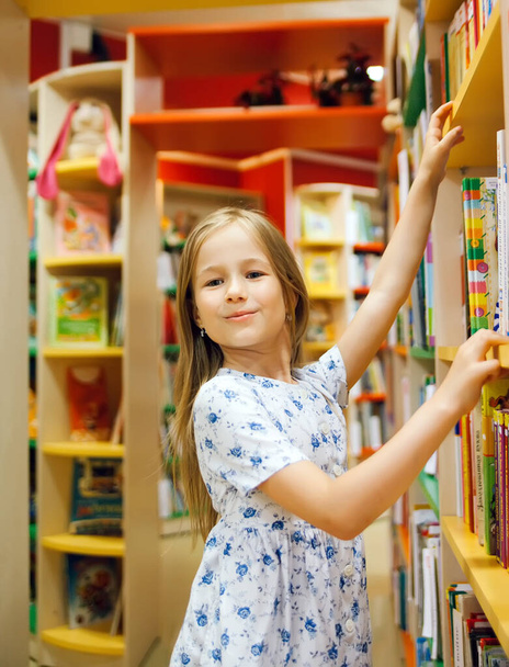   first grader choosing   book in   school library.  - Photo, Image