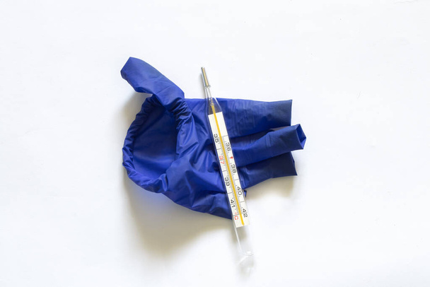 thermomètre en verre et gants bleus sur fond blanc
 - Photo, image