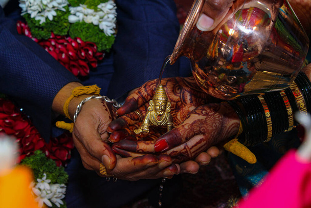 Panna młoda i panna młoda trzymają się za ręce i czczą hinduskiego boga podczas rytuałów ślubnych - Zdjęcie, obraz