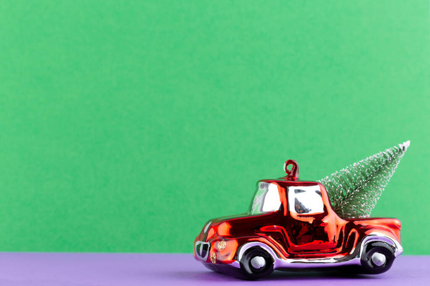 Χριστουγεννιάτικο αυτοκίνητο σε παστέλ χρώμα φόντο. Χριστούγεννα ή Πρωτοχρονιά ελάχιστη έννοια. - Φωτογραφία, εικόνα