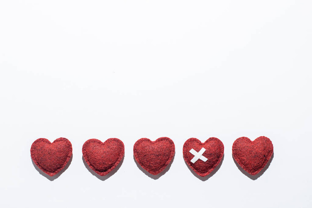 rote weiche Herzen auf weißem Hintergrund, ein Herz mit Pflaster, Herzinfarkt, kardiologische Erkrankungen, Heilungsliebe, unglückliches Liebeskonzept - Foto, Bild