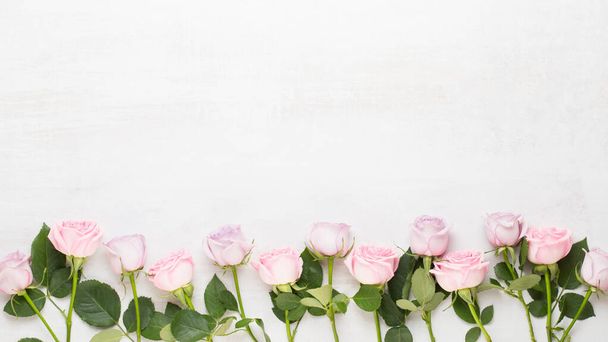 Tarjeta de felicitación de primavera, color pastel rosa sobre el fondo gris. Tarjeta de felicitación de flores. Puesta plana. - Foto, imagen