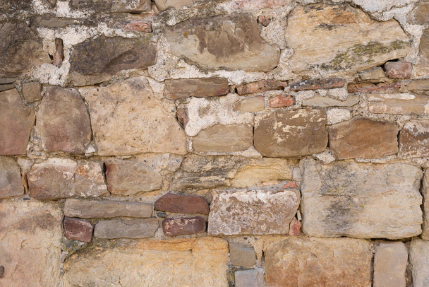 Textured stones stacked on top of each other, between them cement abstract wall and space for text - Foto, imagen
