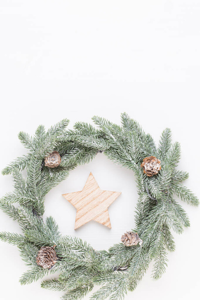 Christmas greeting card. Wreath decoration on white wooden background. New Year concept. Copy space.  Flat lay. Top view. - Foto, Imagem
