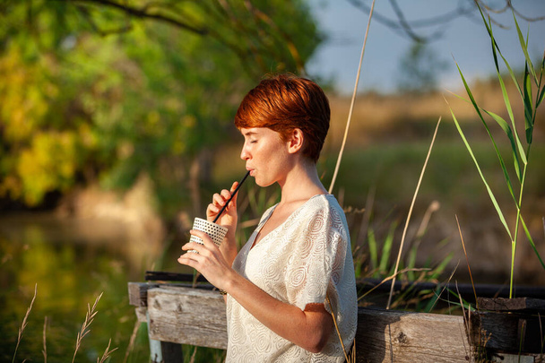 WOMAN DRINKING STRAW IN THE COUNTRYSIDE - Photo, Image