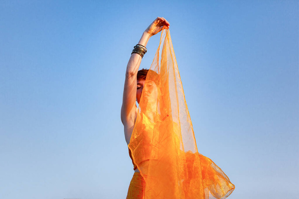 FREEDOM, MOVEMENTS, WOMAN ON A GATEWAY WITH A ORANGE SCARF - Photo, Image