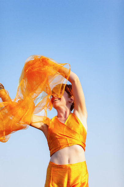 自由、動き、オレンジのスカーフを手にした女性 - 写真・画像