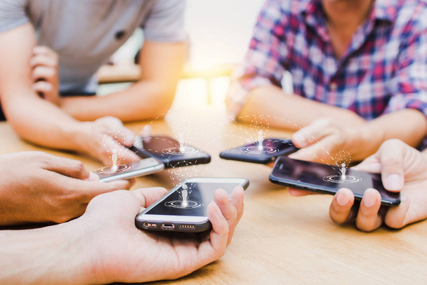 группа людей использует телефон на деревянном столе для подключения и связи, сети и 5G групповой концепции
 - Фото, изображение