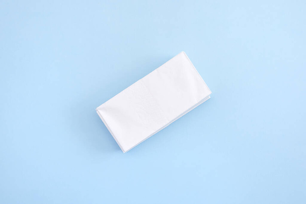 Einwegtaschentücher aus Papier auf blauem Hintergrund. Hygiene. Ansicht von oben. - Foto, Bild