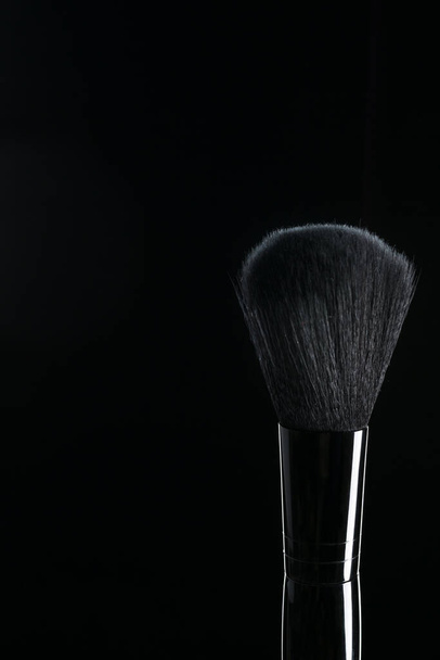 Different makeup brushes were photographed against a black background - Φωτογραφία, εικόνα