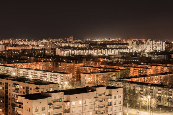 Látványos éjszakai városkép háttérvilágítással és fekete égbolttal, városi építészet elvont háttér - Fotó, kép