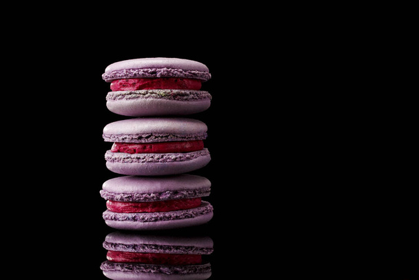 purple macaroon cookies on a black background. - Valokuva, kuva