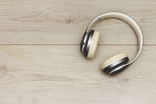 Drahtloser Bluetooth-Kopfhörer oder Kopfhörer auf Holztisch - Foto, Bild