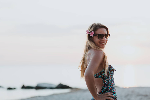 νεαρή γυναίκα απολαμβάνει το ηλιοβασίλεμα στην παραλία - Φωτογραφία, εικόνα