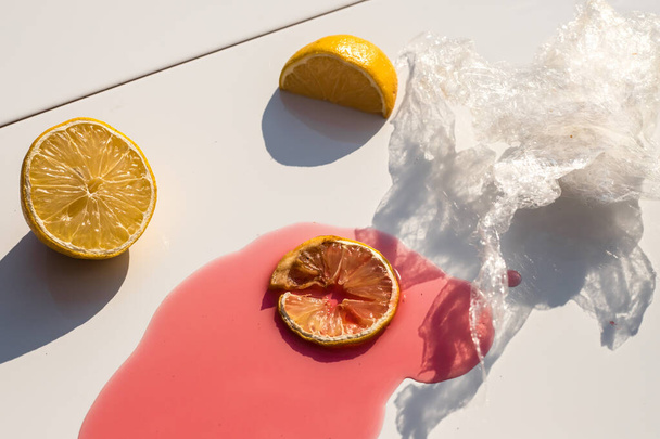 citriques sur fond blanc avec un liquide rouge et une pellicule plastique
 - Photo, image