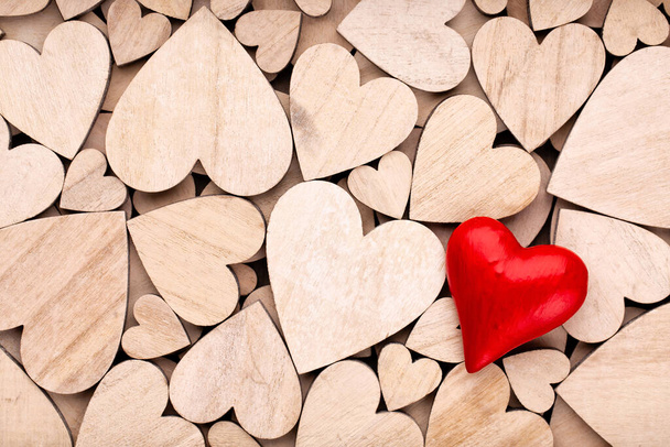 Wooden hearts, one red heart on the wooden heart background. - Foto, afbeelding