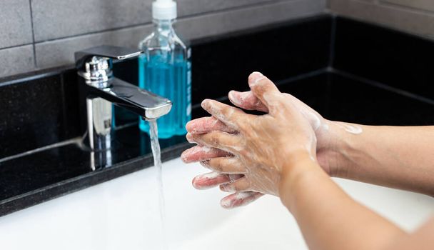Man is washing his hands in a sink sanitizing the colona virus for sanitation and reducing the spread of COVID-19 spreading throughout the world, Hygiene ,Sanitation concept. - Photo, Image