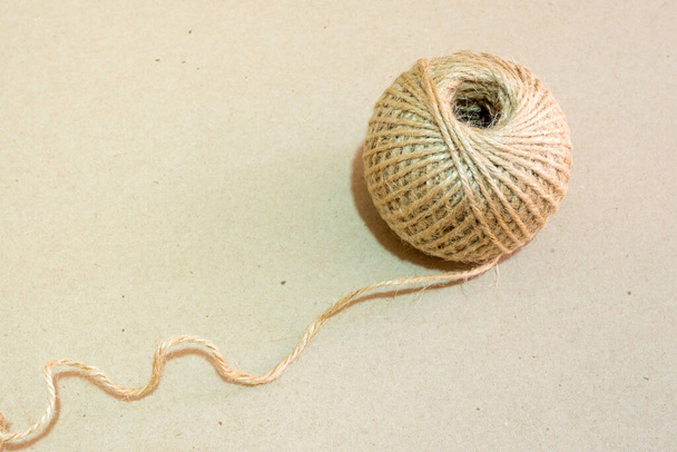 Texture of the brown natural rustic hemp cord in roll on kraft paper texture background - Fotó, kép