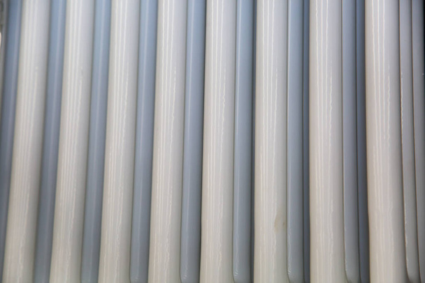 Background of vertical plastic pipes in white. Design backgrounds textures construction. - Foto, Imagem