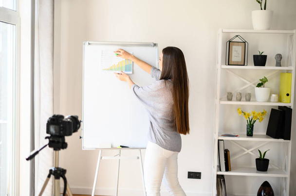 Young woman with flipchart records video lessons - Photo, Image