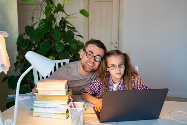 daddy in glasses helps kid girl distance learning - Фото, изображение