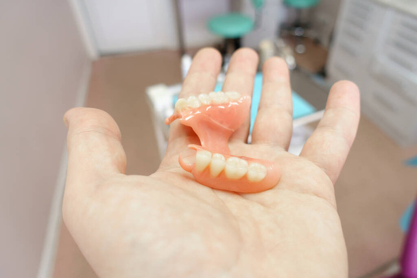 kivehető fogsor a fogorvosi rendelőben orvos kezében - Fotó, kép