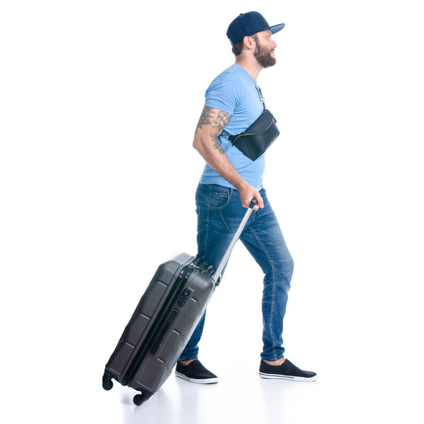 Man in jeans with travel suitcase goes walking - Foto, Imagen