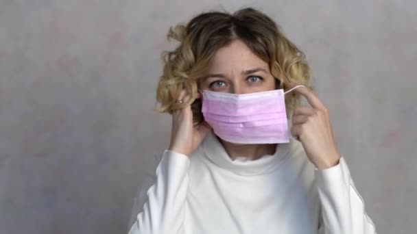 woman putting on surgical mask for corona virus prevention. - Filmati, video