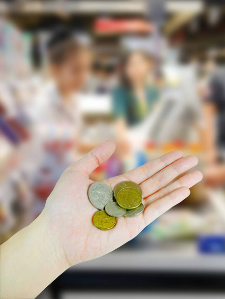 Woman's hand holding Australian coins on supermarket background - Photo, Image
