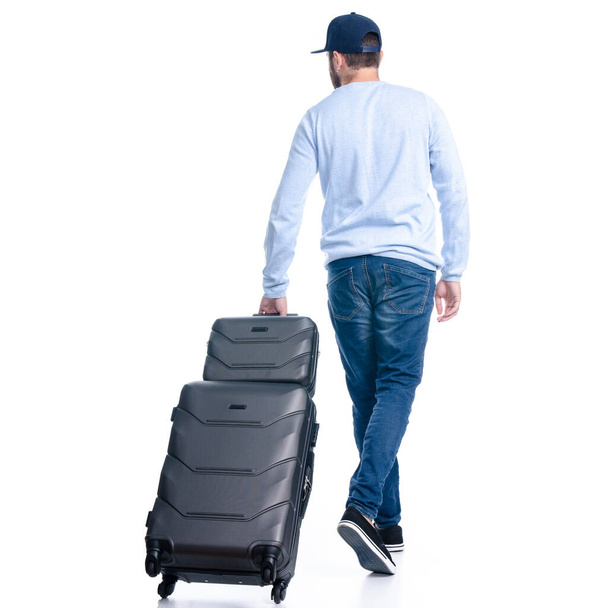 Man in jeans with travel suitcase goes walking - Φωτογραφία, εικόνα