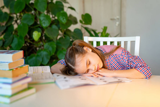 sleepy schoolgirl doing homework. studying at home - Photo, image