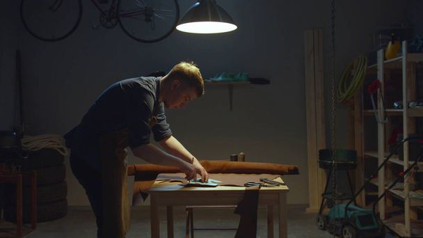 Shoemaker makes a leather pattern at home - Foto, afbeelding