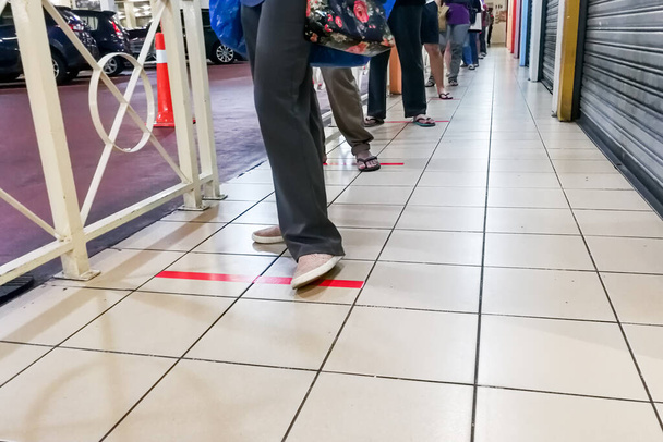 Sosiaalista etäisyyttä harjoitetaan, kun ihmisiä erottaa jonossa oleva vähintään metrin pituinen aukko valintamyymälään Malesiassa
 - Valokuva, kuva