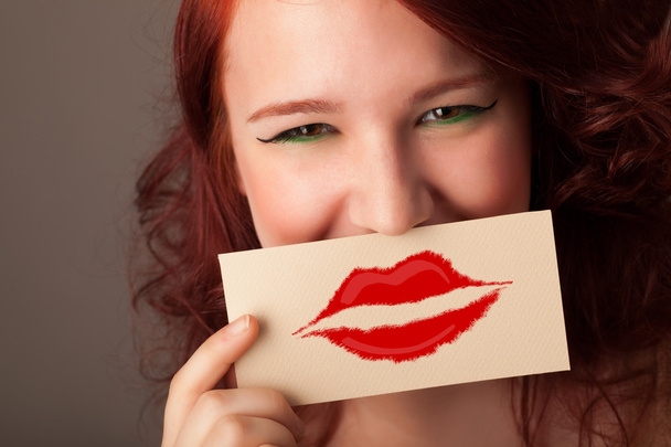 Happy pretty woman holding card with kiss lipstick mark - Fotoğraf, Görsel