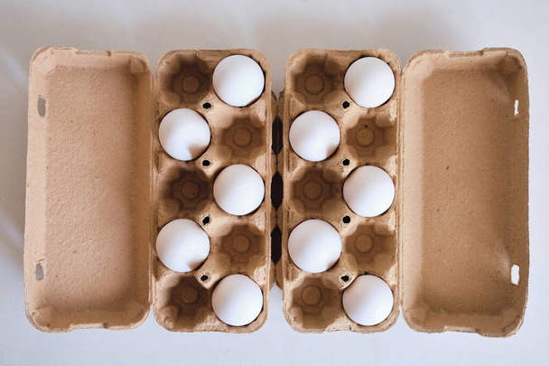 Cardboard boxes with chicken eggs. Boxes with uncooked eggs in table. Natural organic farm product. Preparing for Easter holiday. Fresh food delivery, carton package. Raw ingredient for cooking eat - Φωτογραφία, εικόνα