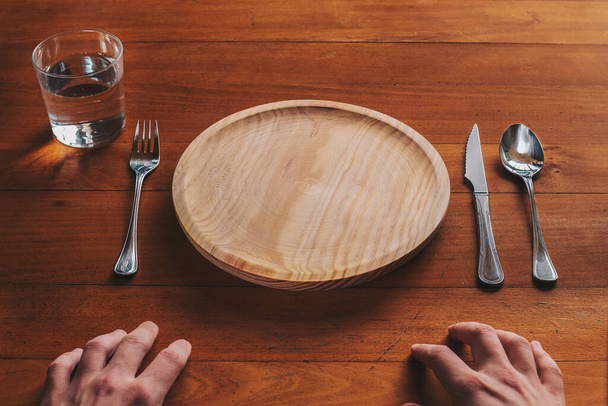Point de vue d'une personne sur le point de manger sur une assiette en bois vide
 - Photo, image