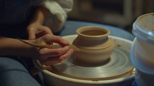 Keramiker schnitzt Muster auf eine Vase. Hobby zu Hause - Foto, Bild