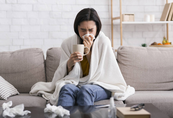 Contagious disease outbreak. Sick girl with warm drink suffering from virus at home - Photo, Image