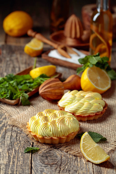 Tartlets with lemon cream and mint on a old wooden table.  - Zdjęcie, obraz