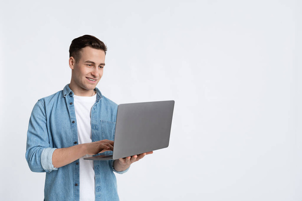 Homme souriant travaillant avec un ordinateur portable, espace de copie
 - Photo, image