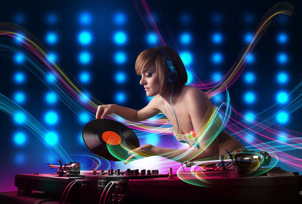 Young Dj girl mixing records with colorful lights - Photo, Image