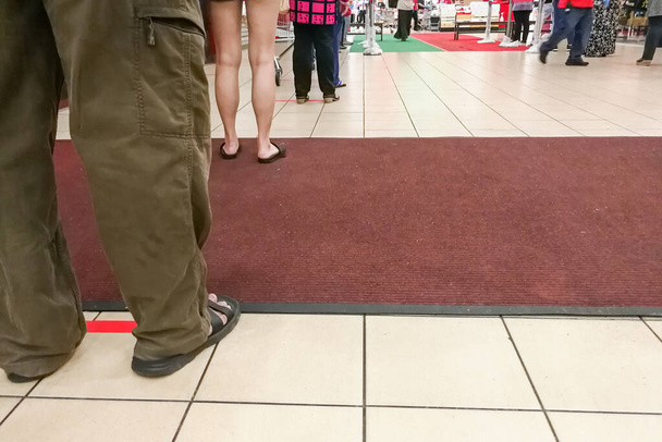 Distanza sociale praticata dove le persone sono separate da uno spazio di almeno 1 metro in coda nel supermercato in Malesia
 - Foto, immagini
