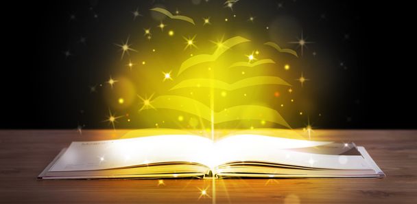 Open book with golden glow flying paper pages - Photo, Image