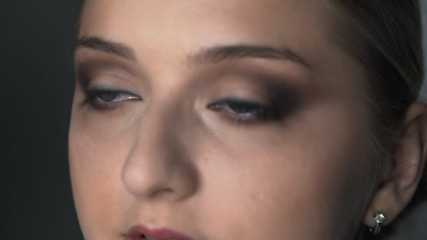 Makro laukaus meikki taiteilija tekee ammatillinen meikki nuori nainen kauneushoitola. Make up Taiteilija käyttää harjaa soveltaa varjo silmäluomen - Materiaali, video