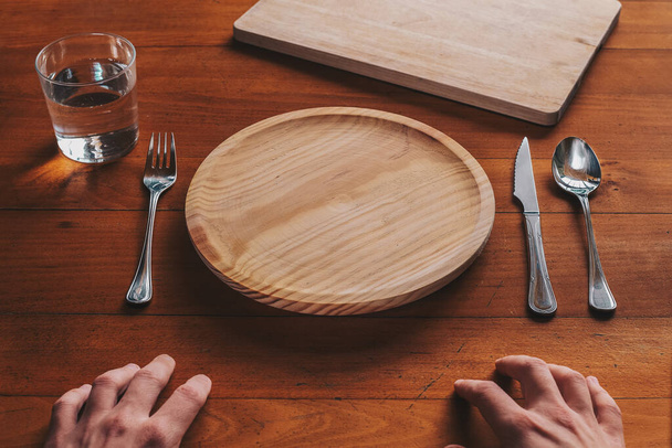 Point de vue d'une personne sur le point de manger sur une assiette en bois vide
 - Photo, image