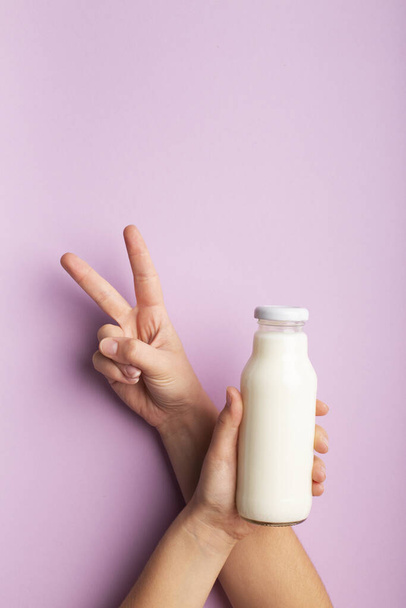 Vegetarisches gesundes Getränk auf Kokosmilch, Frau zeigt V-Zeichen - Foto, Bild