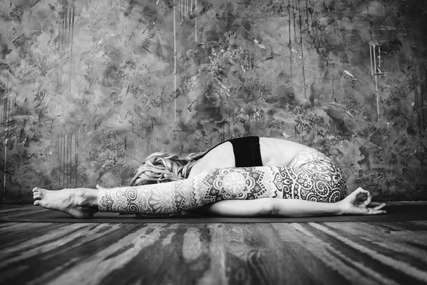Young blonde woman practicing yoga at home. - Fotografie, Obrázek