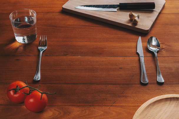 Empty space for a plate and cutlery against a wood background with mediterranean elements - Foto, Imagen